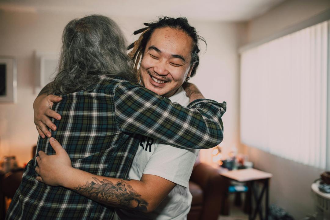 A volunteer embracing a community member outside a relief centre.